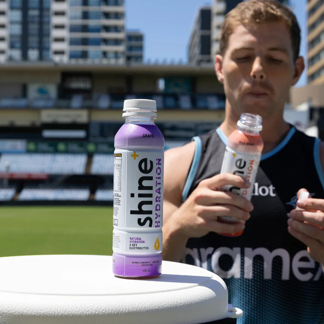 Grape hydration drink bottle and athlete outdoors, natural electrolytes, low sugar beverage