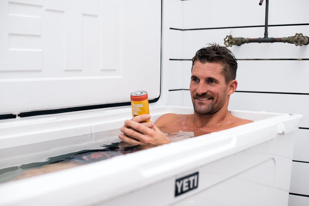 Man relaxing in an ice bath holding a can of nootropic drink for brain and focus support