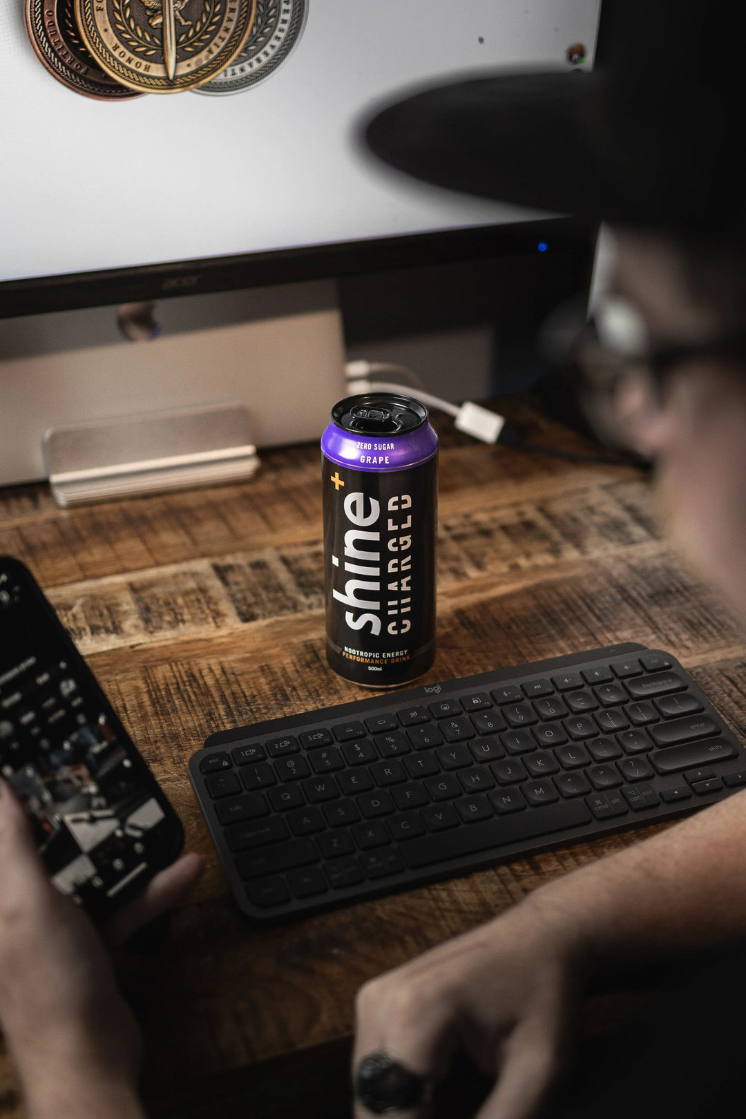 Shine Charged nootropic energy drink can on wooden desk with keyboard and computer monitor