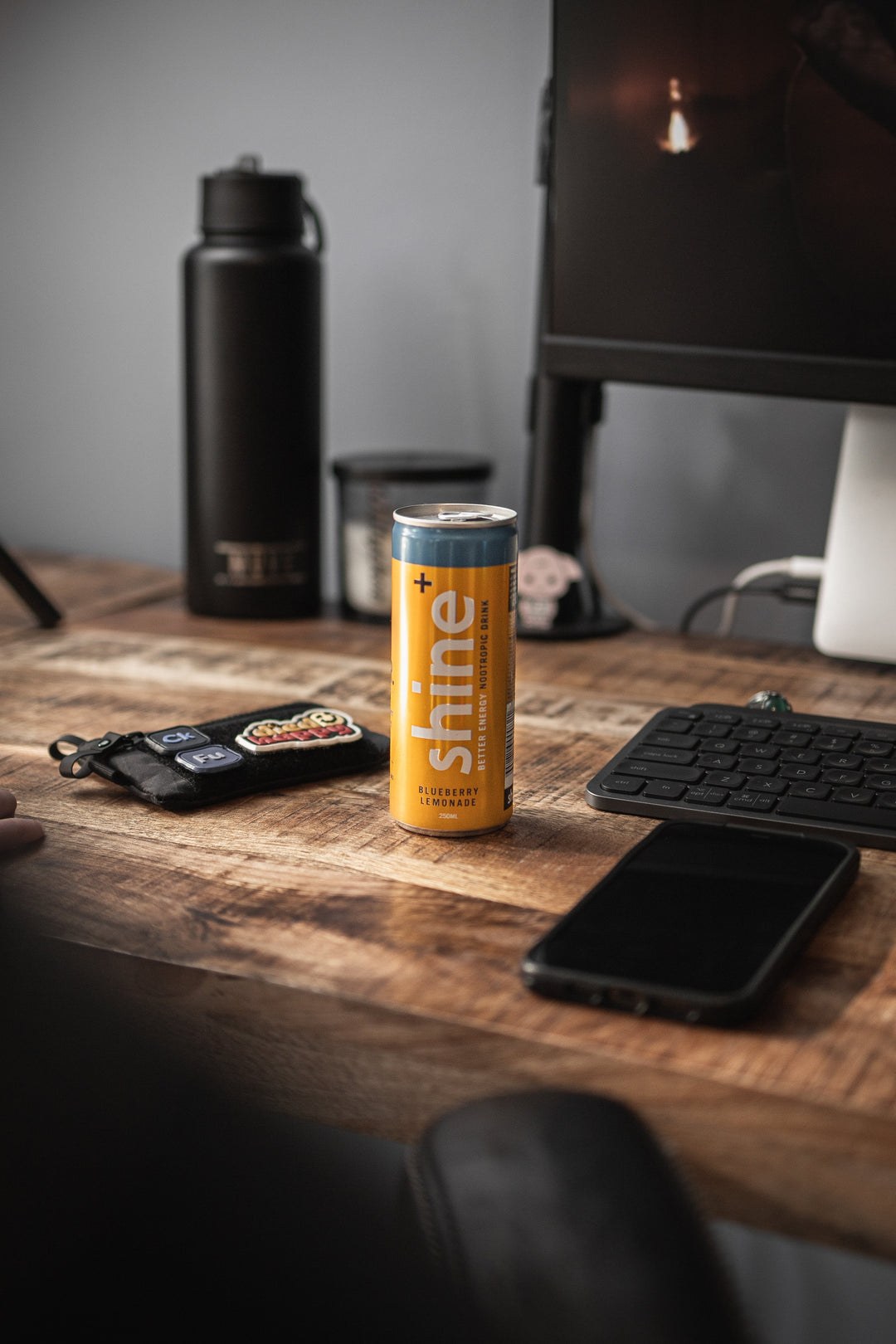Blueberry lemonade nootropic drink can on wooden desk with keyboard and phone