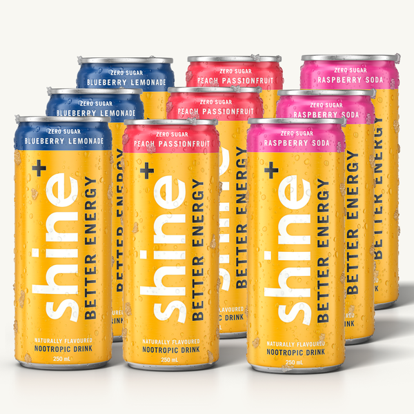 Assorted cans of zero sugar nootropic drinks in Blueberry Lemonade, Peach Passionfruit, and Raspberry Soda flavors with visible water droplets.