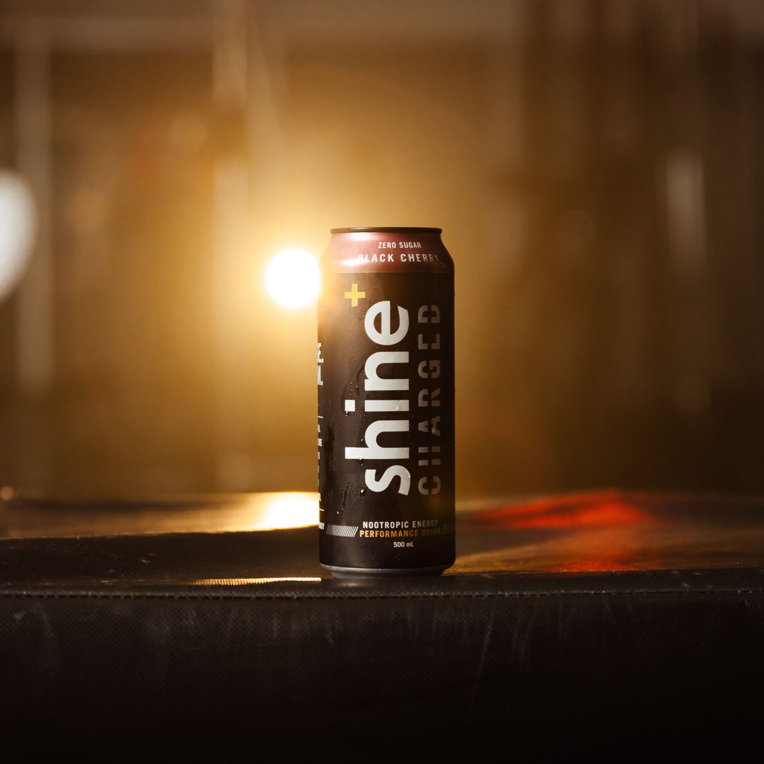 Shine Charged Black Cherry nootropic energy drink can with backlight on dark surface
